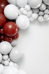 Minimalist balloon decoration with red and white balloons arranged on the left side over a clean white background, creating elegant space for text and festive design layouts.