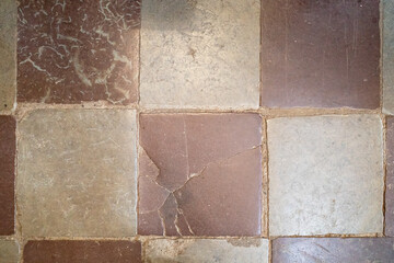 Close-up of old, weathered stone floor tiles with varying colors and textures