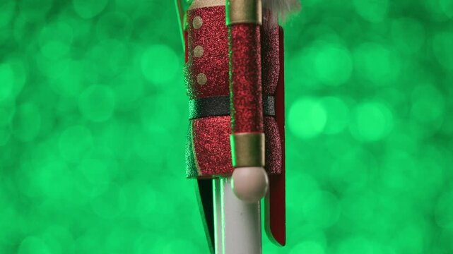 The Nutcracker is spinning to face the camera on a vibrant green background