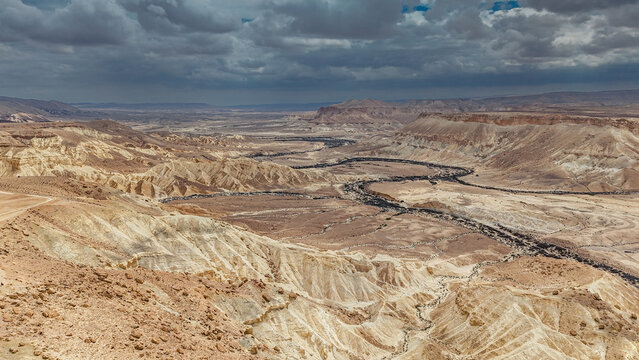 A scenic landscape captured in the Ein Avdat desert canyon region, showcasing dramatic cliffs, natural rock formations, and the unique textures of the Negev landscape. The still image highlights the s