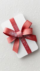 White gift card with red bow and snowflakes on light background