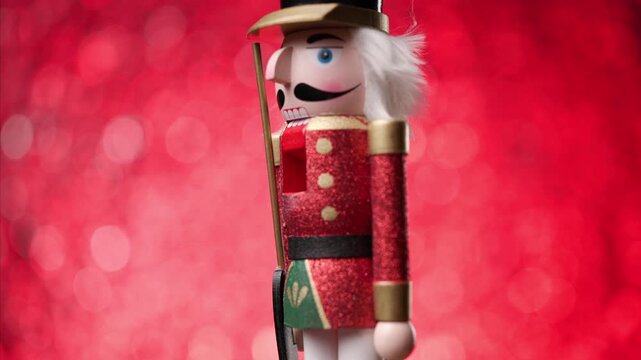 playful Toy Nutcracker twirls against a bright red bokeh background, culminating in a head-focused close-up