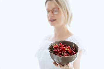Beautiful woman with red currants, healthy food with vitamins, and ingredients for cooking. 