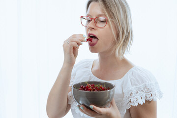 Beautiful woman with red currants, healthy food with vitamins, and ingredients for cooking. 