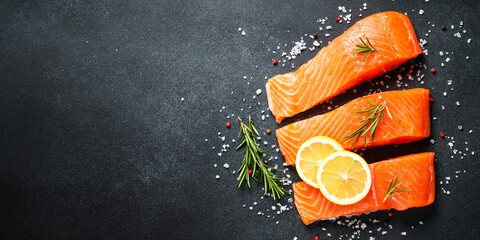 Salmon fillet, raw fresh fish at black table.