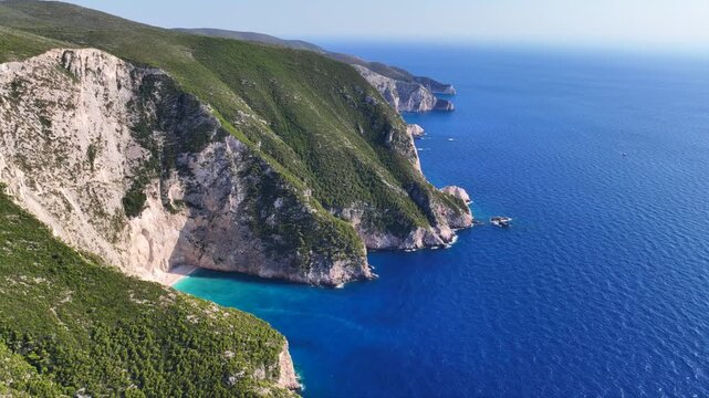 Aerial drone video of not so famous paradise bay and caves of Saint Andrews islet creating a blue lagoon visited by yachts and small boats in the Northern part of Zakinthos island, Ionian Sea, Greece