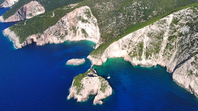 Aerial drone video of not so famous paradise bay and caves of Saint Andrews islet creating a blue lagoon visited by yachts and small boats in the Northern part of Zakinthos island, Ionian Sea, Greece