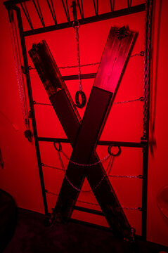 BDSM set. Leather accessories on a wooden cross.