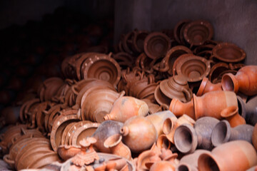 Clay Pottery Collection in Workshop – Handmade ceramic pots, bowls and traditional clay vessels arranged together. Warm rustic colors and detailed craft textures.