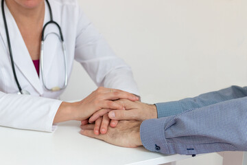 Doctor finding support and empathy with patient by holding hands