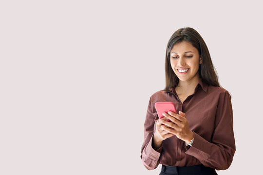 Young Indian business woman manager ceo using cell phone mobile app. Smiling Latin Hispanic mature female businesswoman holding smartphone in office trading, reading, working online. Isolated portrait - Powered by Adobe