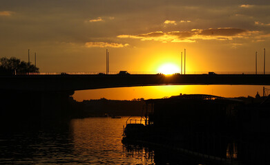 Fototapeta premium sunset on the river with bridge silhoutte