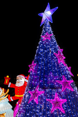 Christmas tree with blue lights and Santa Claus lantern