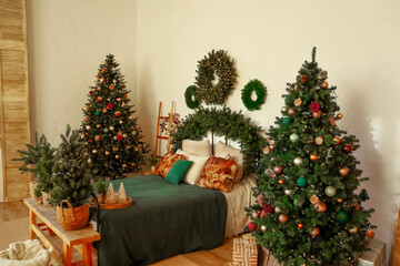 Cozy holiday bedroom decorated with Christmas trees and festive ornaments in a warm setting