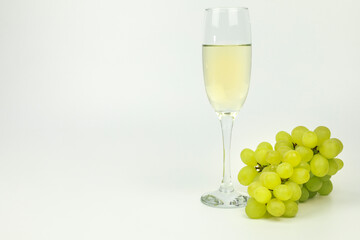 Champagne on classic champagne glass next to bunch of grapes