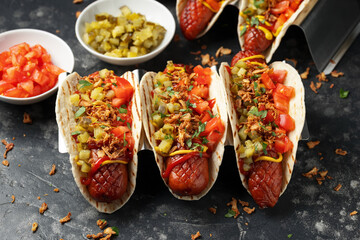 Taco Hot Dog with sausage, pickles, tomatoes and crispy fried onions