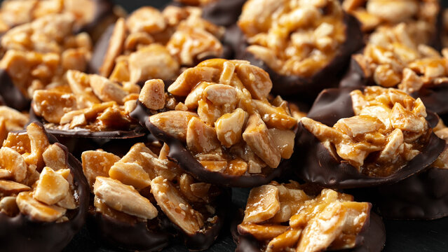 Chocolate Florentines cookies with almonds on a stone board.