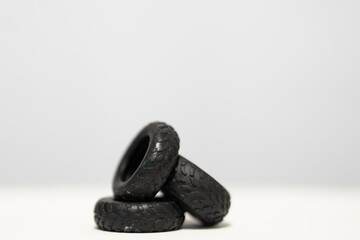 Rubber car tire scale models photographed on a white background, showing realistic tread patterns and miniature detailing