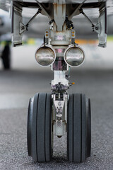 Vertically composed close-up of the nose landing gear of a twin-engine corporate jet, captured...
