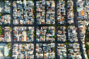 Fototapeta premium A high angle shows densely populated residential and commercial buildings with colorful roofs situated along a grid of streets