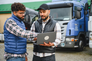 Logistics managers discussing freight transportation plan using laptop