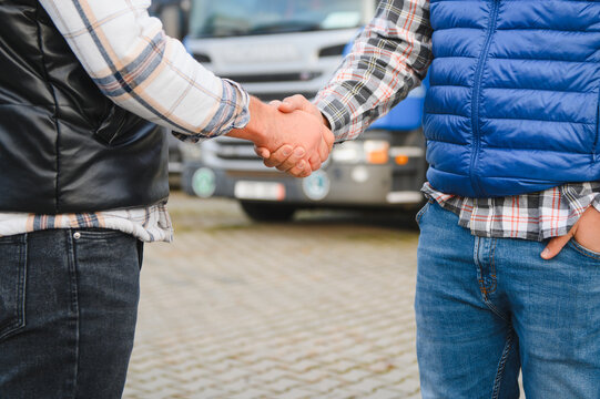 Truck drivers shaking hands making transportation deal