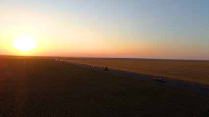 a truck driving on the highway at sunset, drone view