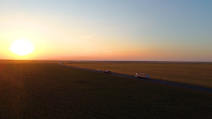 a truck driving on the highway at sunset, drone view