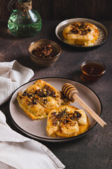 Pumpkin, cheese, nuts and rosemary baked with honey topping on a plate on the table vertical view
