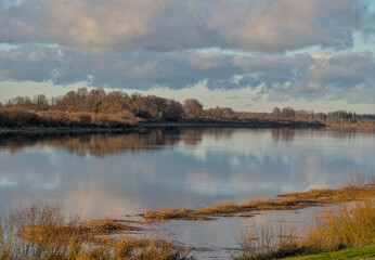 Pastel winter sunset river landscape - Fluffy clouds over wide autumn river