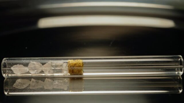 Crystal meth drug in rocks with smoking crack pipe on the table of addict. Addiction and drugs trafficking. Illicit drugs very potent and addictive, substances altered for street sale by drug dealer.