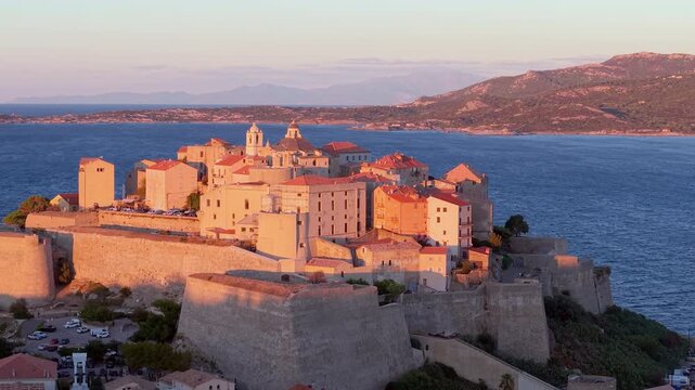 Aerial view of calvi citadel at sunrise with serene waters. Fortress with marina. Corsica. France