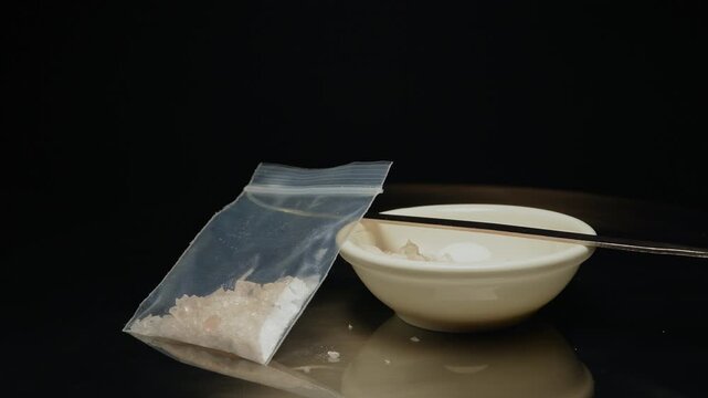 Methamphetamine drug in a plastic bag. Crystal meth or methamphetamine a recreational and highly potent and addictive drug. Crack cocaine in hard form of crystals. Addiction and drug trafficking.