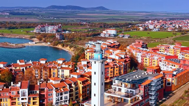 Flight around the top of the beautiful Aheloy Lighthouse. View on the red roofs of the bright Marina Cape complex in Aheloy, Bulgaria.