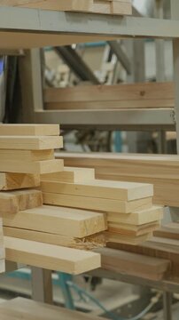 Stacked lumber fills a warehouse, neatly organized on shelving. Concept of resourcefulness, construction, or sustainable forestry is conveyed.