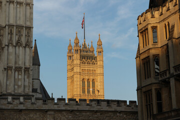 Obraz premium Historic architecture of the Houses of Parliament in London, showcasing the iconic Big Ben tower under a clear blue sky
