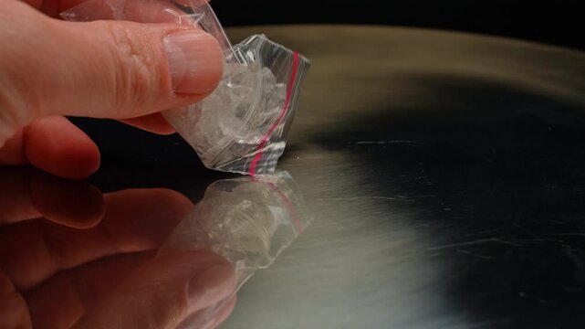 Methamphetamine drug in a plastic bag. Crystal meth or methamphetamine a recreational and highly potent and addictive drug. Crack cocaine in hard form of crystals. Addiction and drug trafficking.