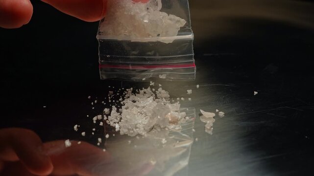 Methamphetamine drug in a plastic bag. Crystal meth or methamphetamine a recreational and highly potent and addictive drug. Crack cocaine in hard form of crystals. Addiction and drug trafficking.