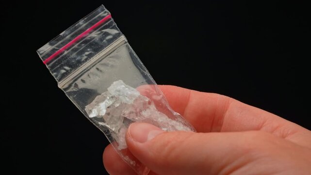 Drug dealer showing Fentanyl Crystal meth or Crack Cocaine for sale and distribution. Drug trafficking and addictioncrisis. Crystals use in glass tube or stems and primarily smoking or as powder.