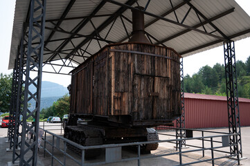 Rear view of the colossal steam shovel (1922) excavator, highlighting the weathered wooden structure, chimney, and heavy-duty tracks beneath a shed.