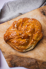Freshly Baked Sweet Bun with Pearl Sugar on Rustic Wooden Board. Scandinavian Style.