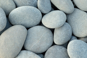 Pebbles stones on seashore as  texture background for design web banner template page. many stones and they are different in color and size dry stones illuminated by sun