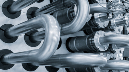 Stainless steel pipes attached to stainless steel tank with industrial food production machine, industrial concept background.