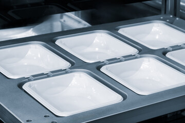 Automatic polyethylene plastic bag production machine with lighting effect. Close-up of the roller of the plastic bag production machine in the light blue scene. product packaging concept