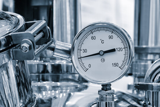 A black and silver pressure gauge is attached to a pipe. The gauge is set at a pressure of 16 Mpa