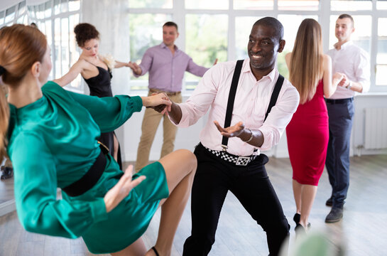 Pair of woman and African American man enjoying of contemporary boogie woogie dance in choreo class. Exciting hobby, active lifestyle, passion for dancing and choreography