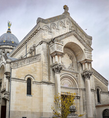 Majestic stone facade of the Basilica of Saint Martin with a large dome and statue stands in Tours France creating a beautiful historic religious architectural city landmark view