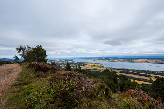 Hiking up the Fyrish Hill (Cnoc Fhaoighris) near Alness, northern Scotland on a cloudy day.
