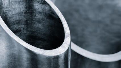 Vertical metal pipes cut diagonally by industrial cutting saw machine, metalworking industrial concept background.