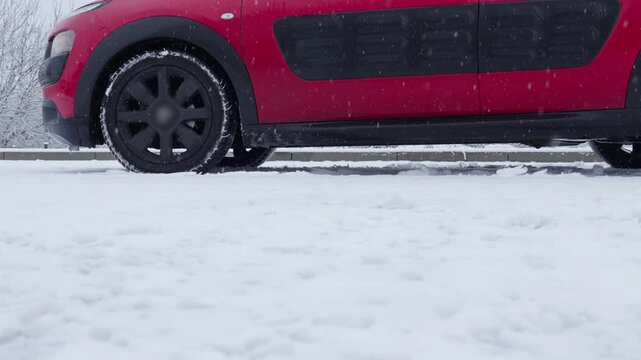 Car brakes engage on icy slope with wheels slipping during winter drive